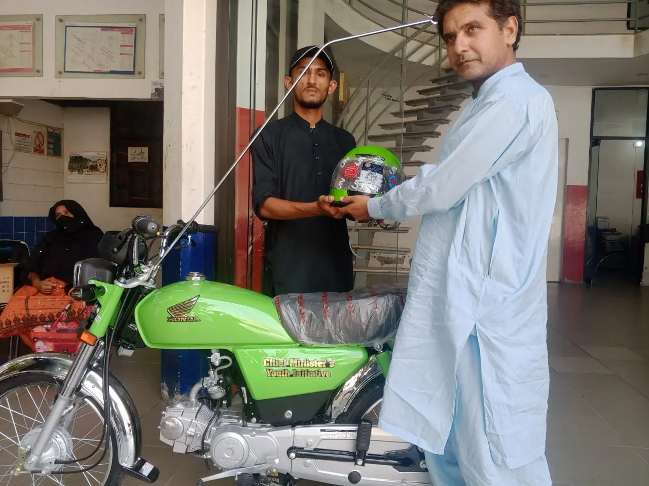 Students gathered at a dealership on scheme delivery day in Punjab