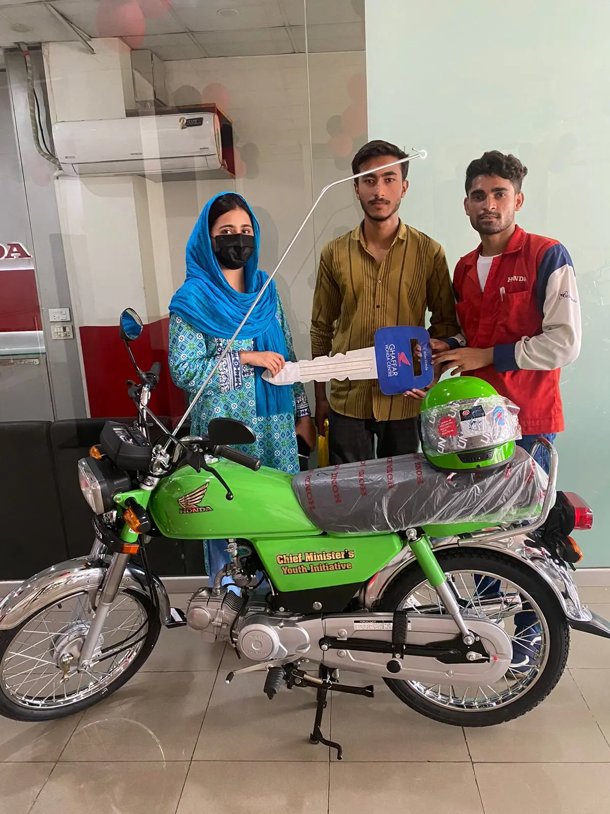 A student signing scheme delivery paperwork beside his new bike