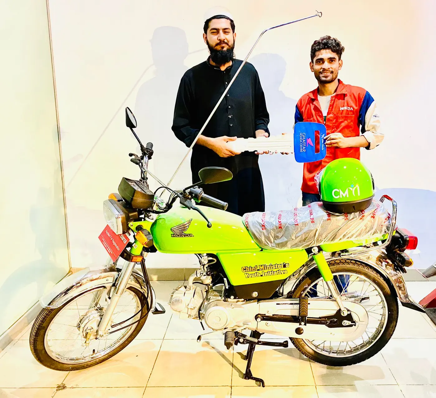 A student beneficiary outside his college with his new scheme bike