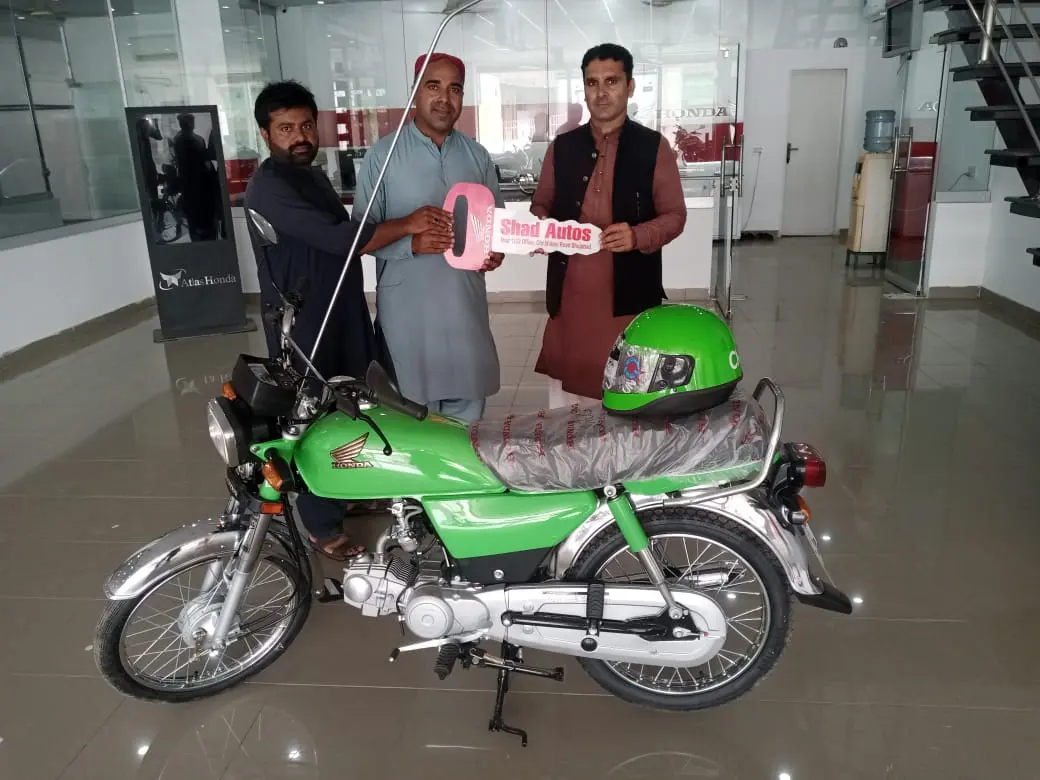 A beneficiary completing official paperwork for his scheme bike