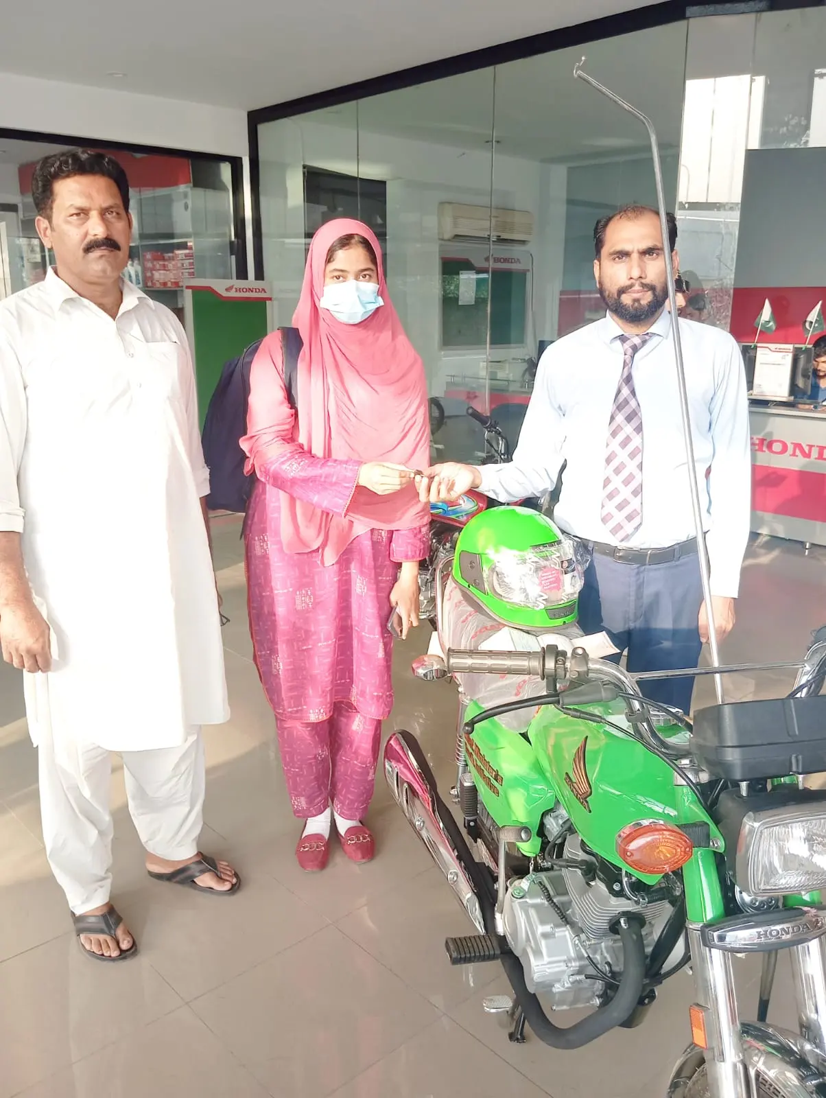 A family together at the dealership collecting their scheme bike