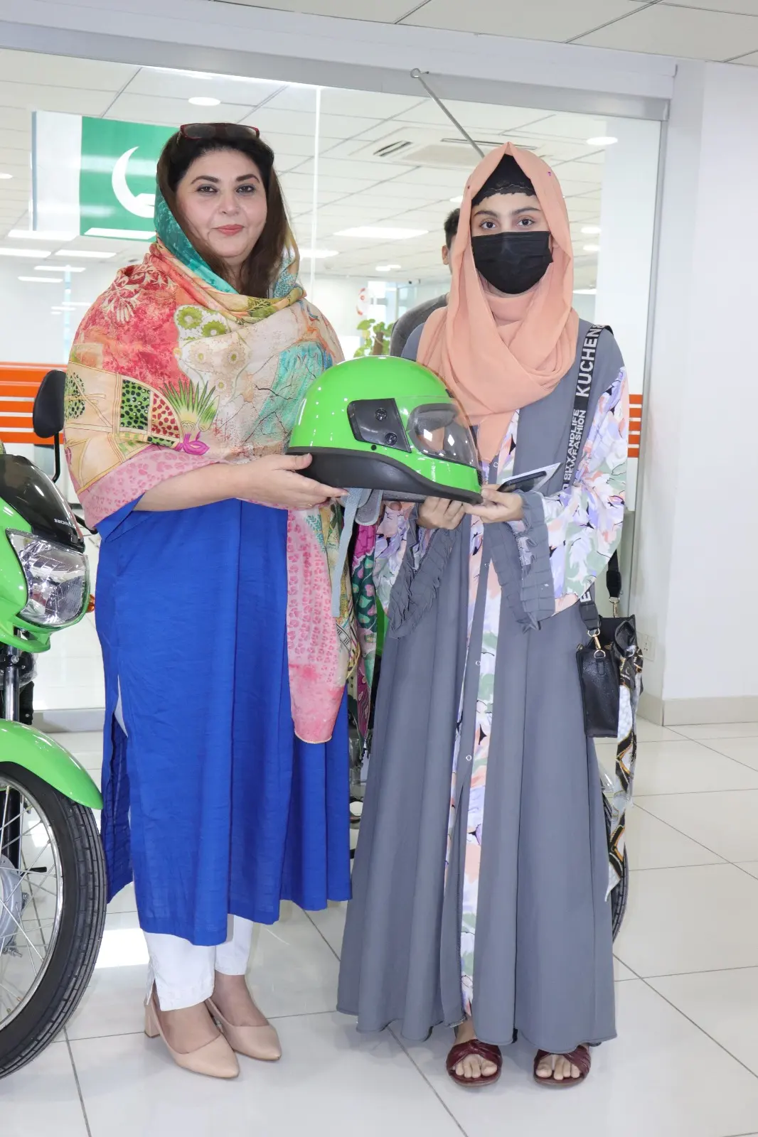 A beneficiary and his father completing bike financing formalities together