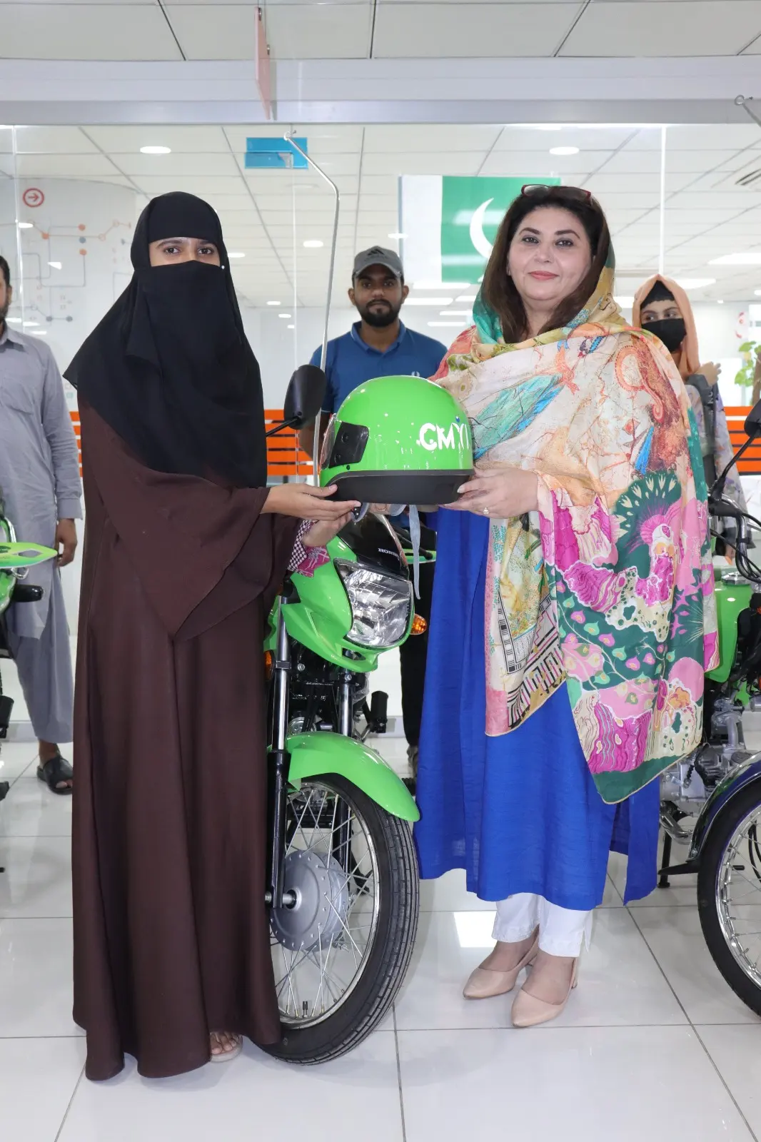 A female student with her new scheme scooty outside her college